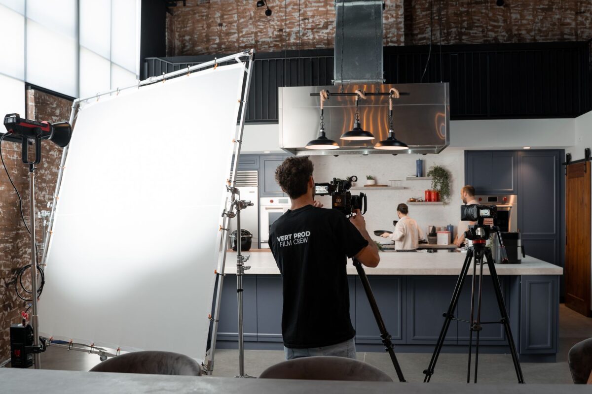 Équipe de tournage filmant une scène en cuisine sur un plateau de série